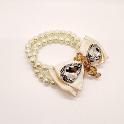 LOT 96:: Triple Strand Faux Glass Pearls with Accent Bow, Matching Bracelet and a Goldtone CZ Pendant Necklace by Express