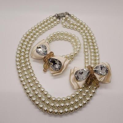 LOT 96:: Triple Strand Faux Glass Pearls with Accent Bow, Matching Bracelet and a Goldtone CZ Pendant Necklace by Express
