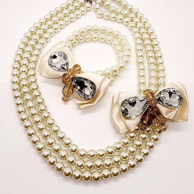 LOT 96:: Triple Strand Faux Glass Pearls with Accent Bow, Matching Bracelet and a Goldtone CZ Pendant Necklace by Express