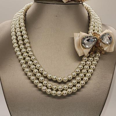LOT 96:: Triple Strand Faux Glass Pearls with Accent Bow, Matching Bracelet and a Goldtone CZ Pendant Necklace by Express