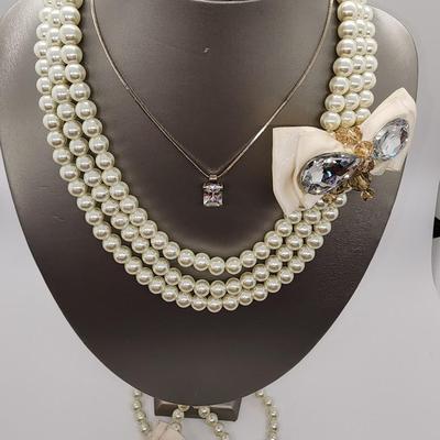 LOT 96:: Triple Strand Faux Glass Pearls with Accent Bow, Matching Bracelet and a Goldtone CZ Pendant Necklace by Express