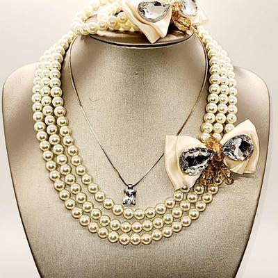 LOT 96:: Triple Strand Faux Glass Pearls with Accent Bow, Matching Bracelet and a Goldtone CZ Pendant Necklace by Express