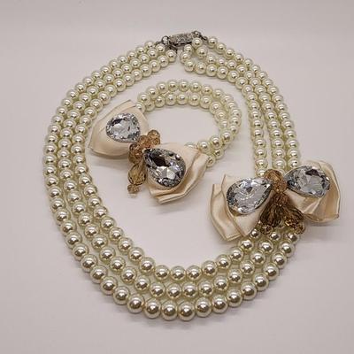 LOT 96:: Triple Strand Faux Glass Pearls with Accent Bow, Matching Bracelet and a Goldtone CZ Pendant Necklace by Express