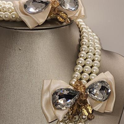 LOT 96:: Triple Strand Faux Glass Pearls with Accent Bow, Matching Bracelet and a Goldtone CZ Pendant Necklace by Express