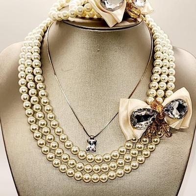 LOT 96:: Triple Strand Faux Glass Pearls with Accent Bow, Matching Bracelet and a Goldtone CZ Pendant Necklace by Express
