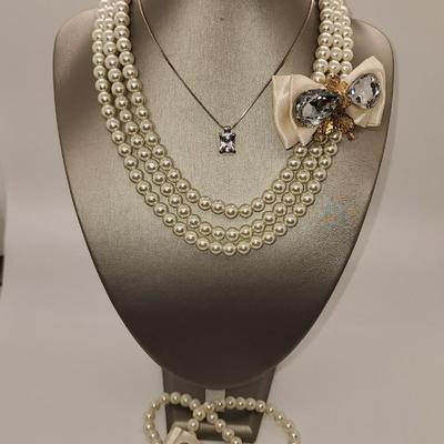 LOT 96:: Triple Strand Faux Glass Pearls with Accent Bow, Matching Bracelet and a Goldtone CZ Pendant Necklace by Express