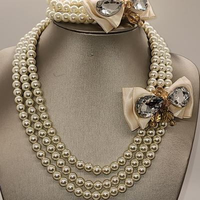 LOT 96:: Triple Strand Faux Glass Pearls with Accent Bow, Matching Bracelet and a Goldtone CZ Pendant Necklace by Express