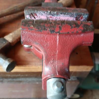 Small workbench mount vice with assortment of hammers