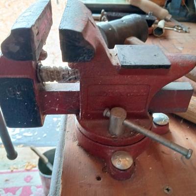 Small workbench mount vice with assortment of hammers