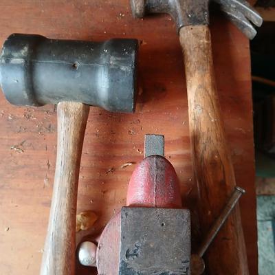 Small workbench mount vice with assortment of hammers