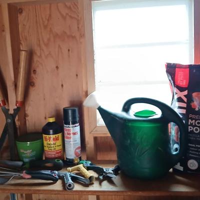 Yard & Garden tools and plant chemicals with potting spoil and a watering can