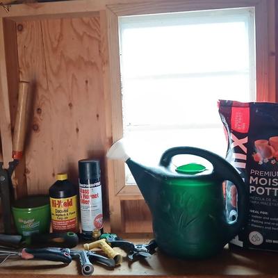Yard & Garden tools and plant chemicals with potting spoil and a watering can