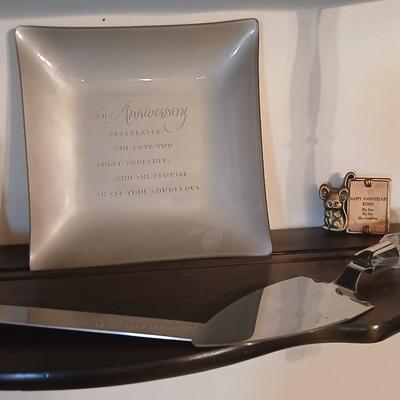 Wooden wall shelf with anniversary collectibles including pie and knife serving utensils