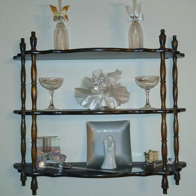 Wooden wall shelf with anniversary collectibles including pie and knife serving utensils