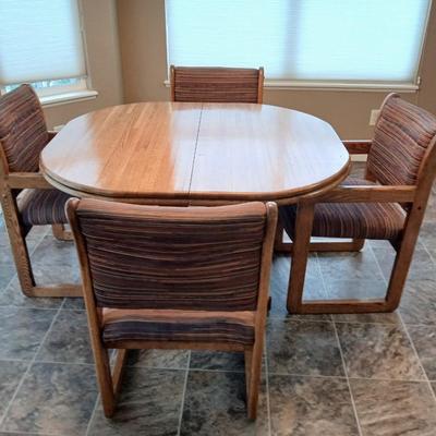 Beautiful slat oak dining room table with 4 upholstered chairs and 2 leaves