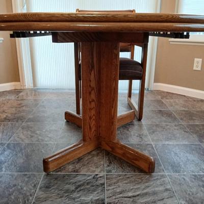 Beautiful slat oak dining room table with 4 upholstered chairs and 2 leaves