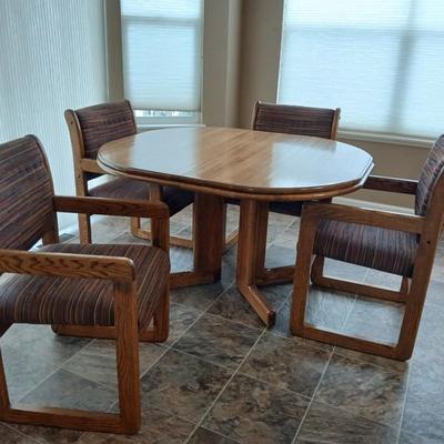 Beautiful slat oak dining room table with 4 upholstered chairs and 2 leaves