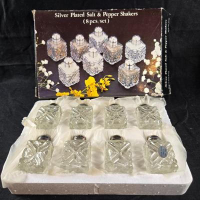 Sale Photo Thumbnail #482: This auction lot is for a Boxed Set of Individual Salt & Pepper Shakers. This boxed set includes 8 pairs of silver-plated caps with glass salt and pepper shakers.  The box is a tad tattered but the shakers have never been used.  Perfect for your next dinn