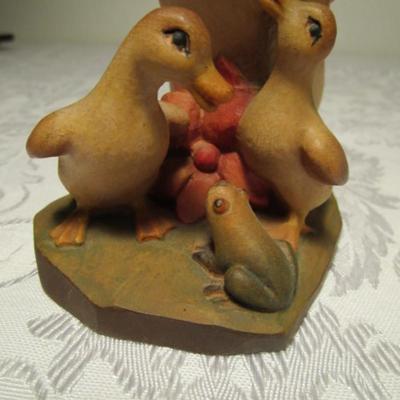Hand-carved Duck family  looking at a Frog