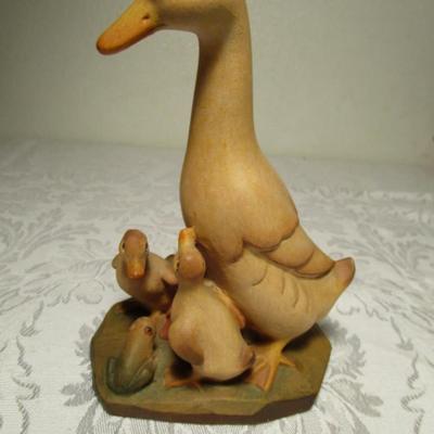 Hand-carved Duck family  looking at a Frog