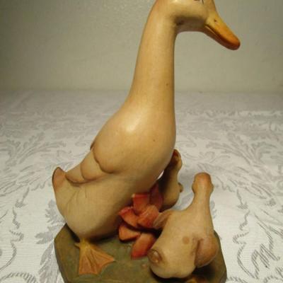 Hand-carved Duck family  looking at a Frog