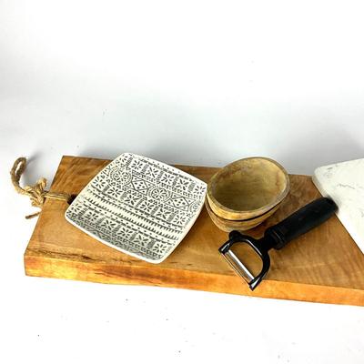 Sale Photo Thumbnail #135: A beautiful combination of kitchen essentials, including a long cutting board (23.5" W x 7" H), a marble cheese slicer, and a stylish BOMSHBEE cutting board. Perfect for serving and preparing food.