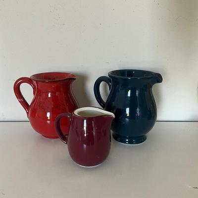 Sale Photo Thumbnail #1110: One Blue kettle
One Red Kettle
One Burgundy Kettle
One Teal Pitcher
One measures: 5.5" high x 4" wide
Teal Pitcher measures: Measures: 8" high x 9.5" wide