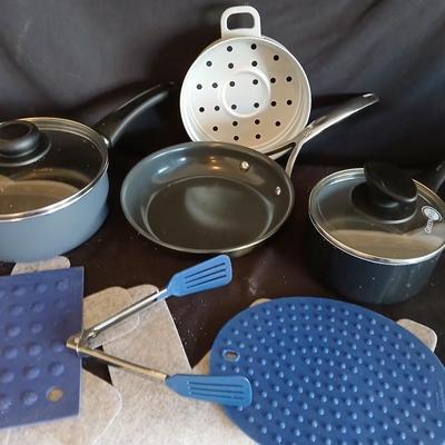 Variety of cooking pans and saucepans with silicone server and hot pads
