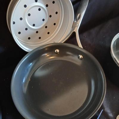 Variety of cooking pans and saucepans with silicone server and hot pads