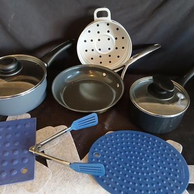 Variety of cooking pans and saucepans with silicone server and hot pads