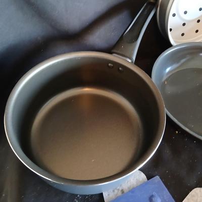 Variety of cooking pans and saucepans with silicone server and hot pads