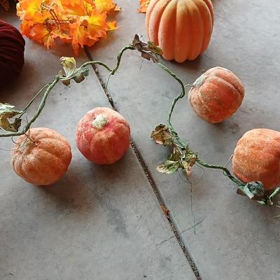 Faux fall leaves with pumpkins on a vine and three decorative pumpkins