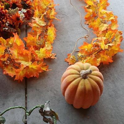 Faux fall leaves with pumpkins on a vine and three decorative pumpkins