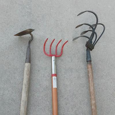 An older harrowing tool, a hoe and a cultivator