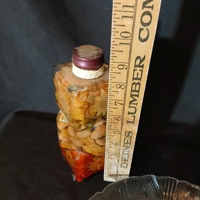 Two decorative garnish bottles with a glass plate and faux fruit