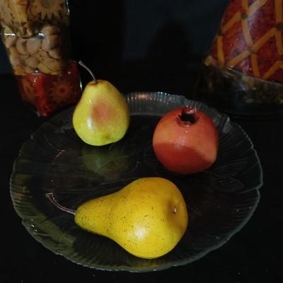 Two decorative garnish bottles with a glass plate and faux fruit