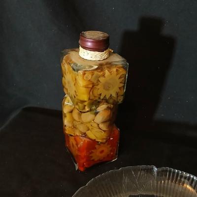 Two decorative garnish bottles with a glass plate and faux fruit