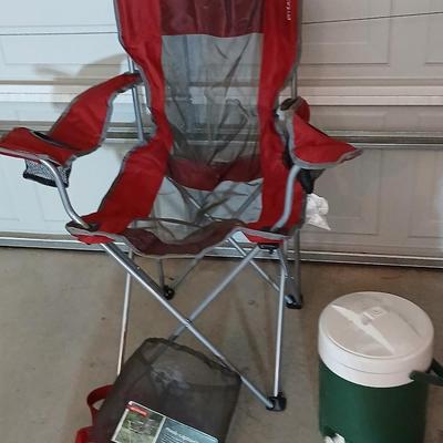 Mesh folding camp chair with carry bag and a green igloo drink cooler