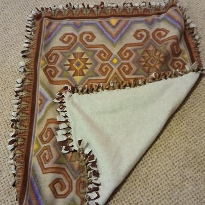 Two throw pillows and a handmade knot lap blanket