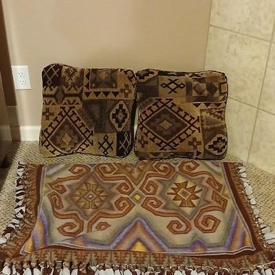 Two throw pillows and a handmade knot lap blanket