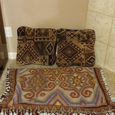 Two throw pillows and a handmade knot lap blanket