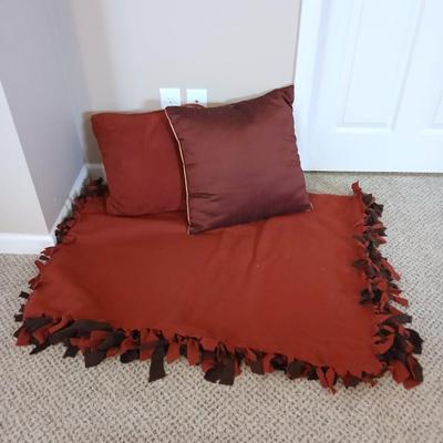 Two throw pillows and a handmade knot lap blanket