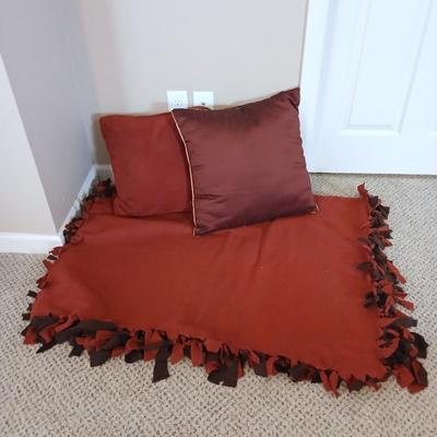 Two throw pillows and a handmade knot lap blanket