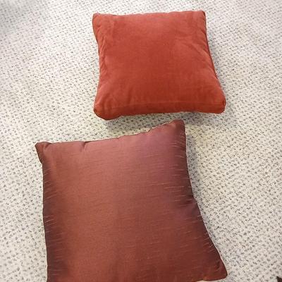 Two throw pillows and a handmade knot lap blanket
