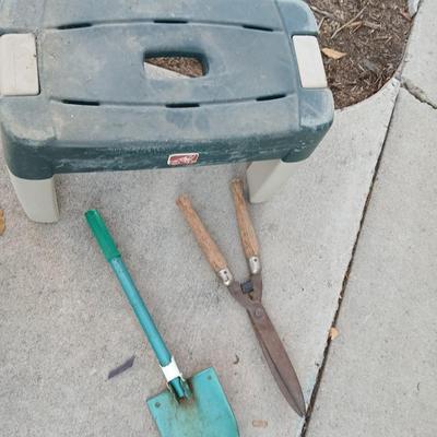 Two step plastic gardening bench with a pair of trimmers and a small pack shovel