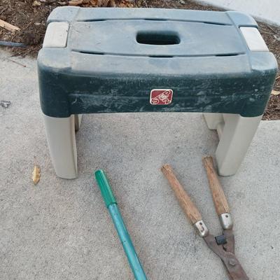 Two step plastic gardening bench with a pair of trimmers and a small pack shovel