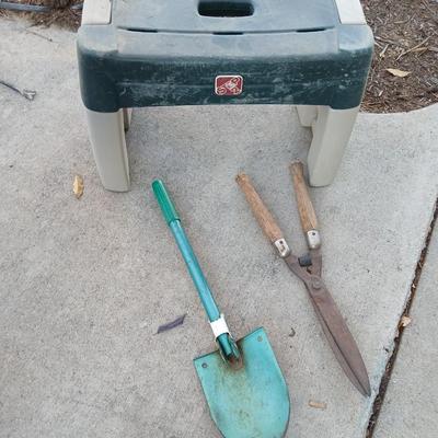 Two step plastic gardening bench with a pair of trimmers and a small pack shovel