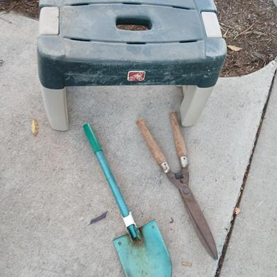 Two step plastic gardening bench with a pair of trimmers and a small pack shovel