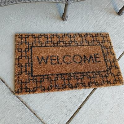 Plastic Wicker like patio bench with nice Welcome mat