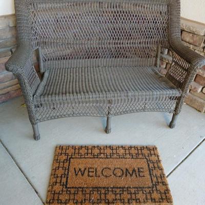 Plastic Wicker like patio bench with nice Welcome mat